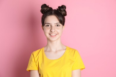 Portrait of smiling teenage girl on pink background