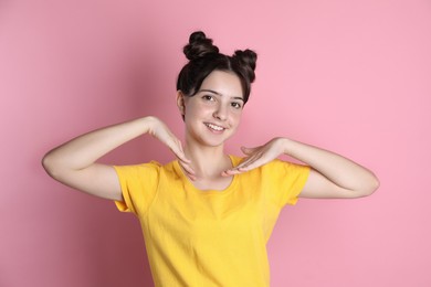 Portrait of smiling teenage girl on pink background