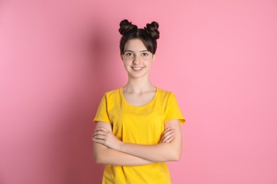 Portrait of smiling teenage girl on pink background