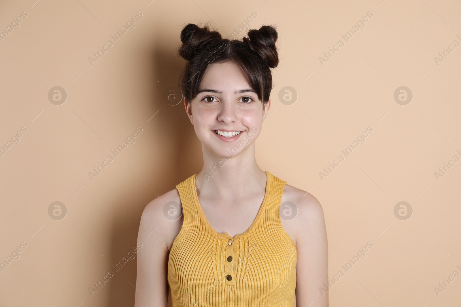 Photo of Portrait of smiling teenage girl on beige background