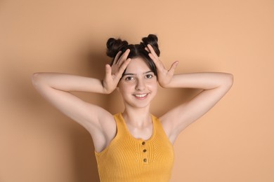 Photo of Portrait of smiling teenage girl on beige background