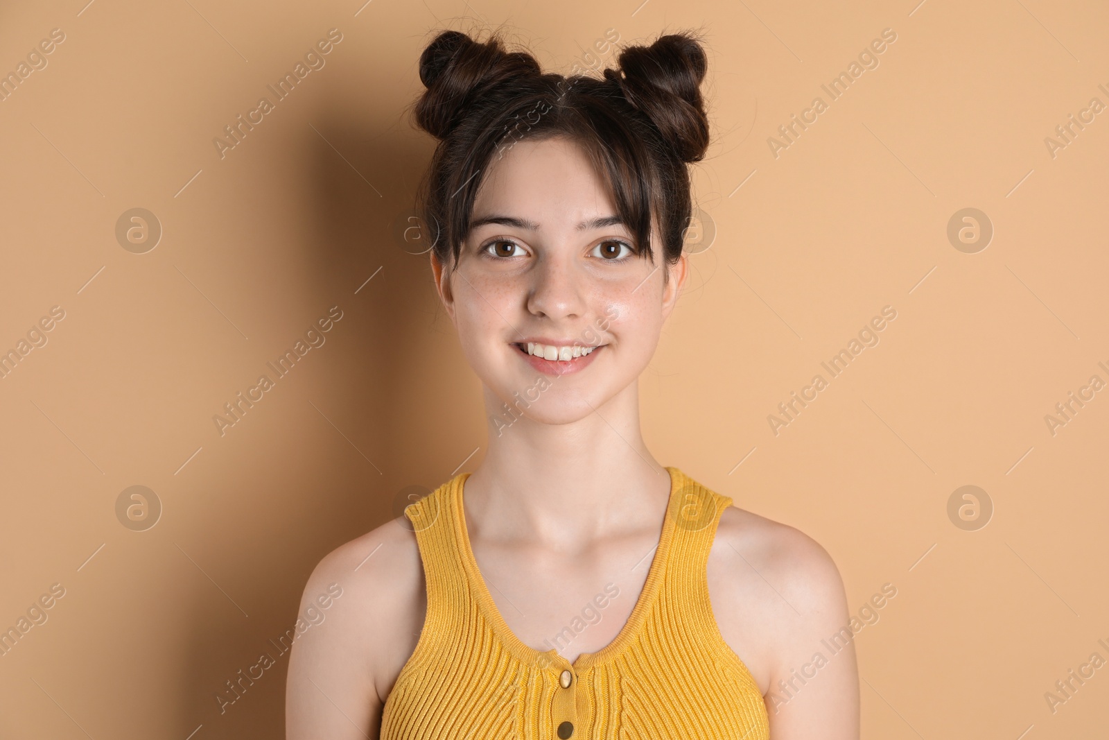 Photo of Portrait of smiling teenage girl on beige background