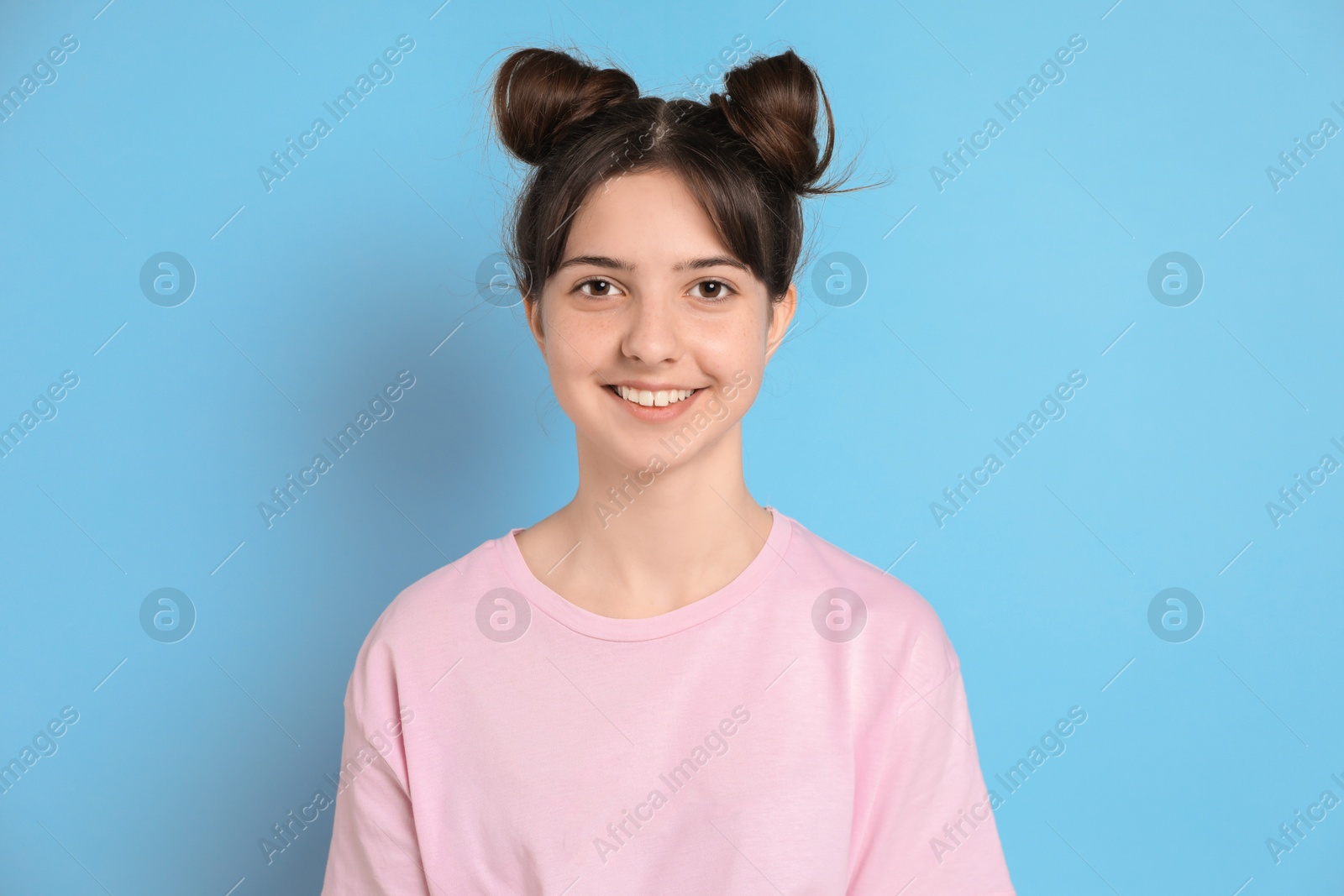 Photo of Portrait of smiling teenage girl on light blue background