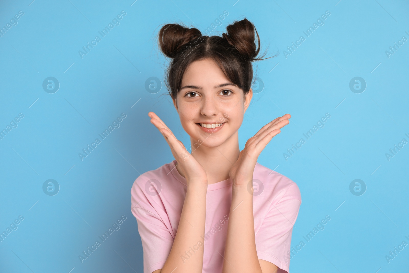 Photo of Portrait of smiling teenage girl on light blue background