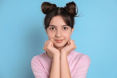 Photo of Portrait of cute teenage girl on light blue background