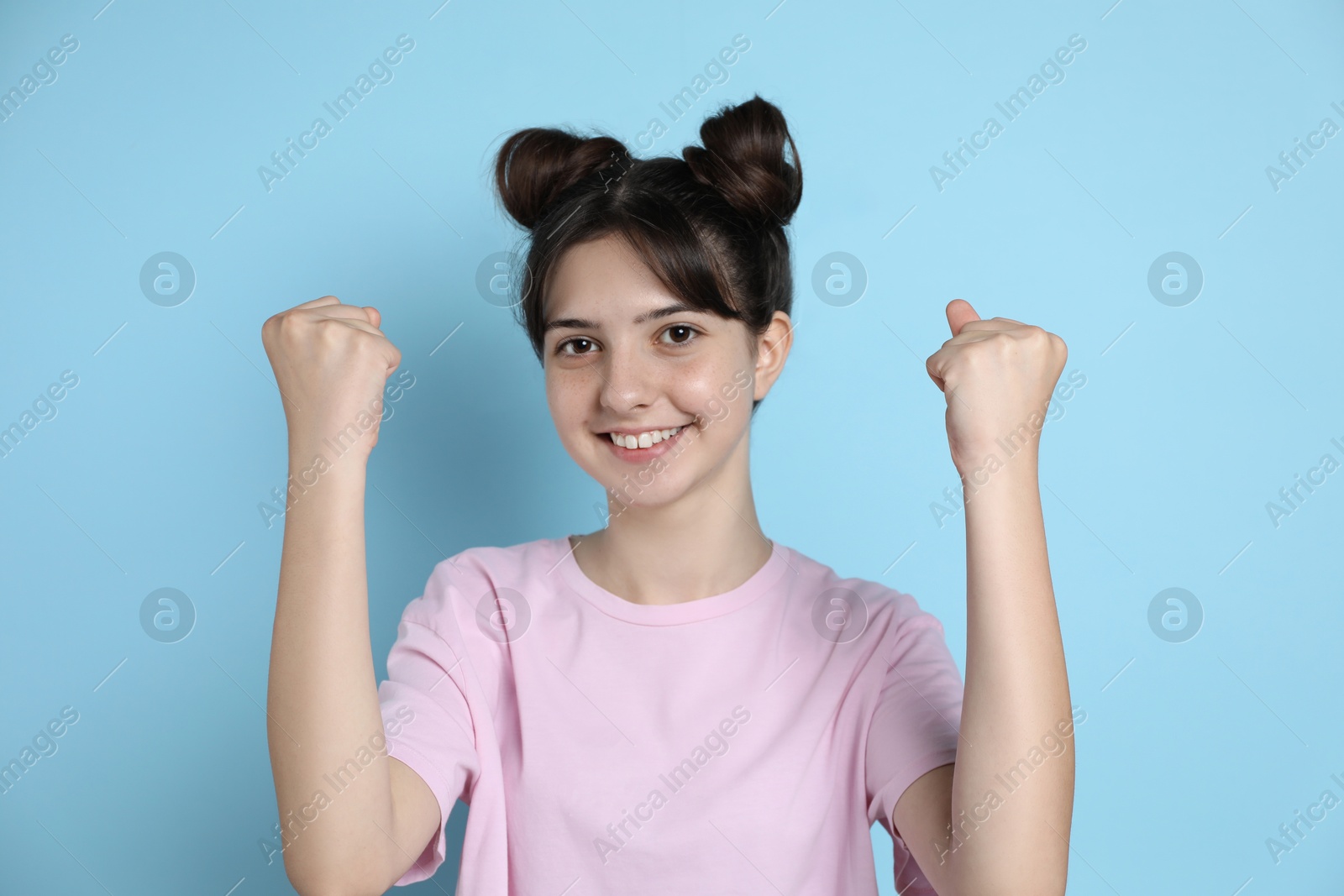 Photo of Portrait of smiling teenage girl on light blue background