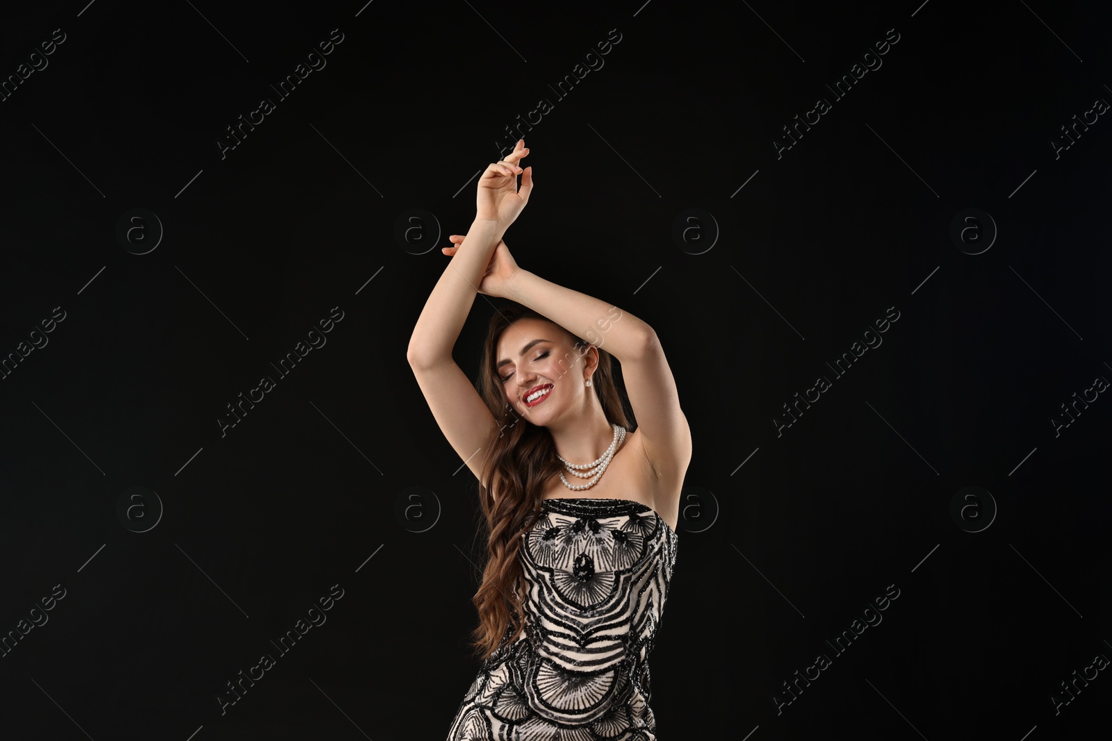 Photo of Portrait of smiling woman dancing on black background