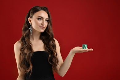 Photo of Charming woman with poker chips on red background. Space for text