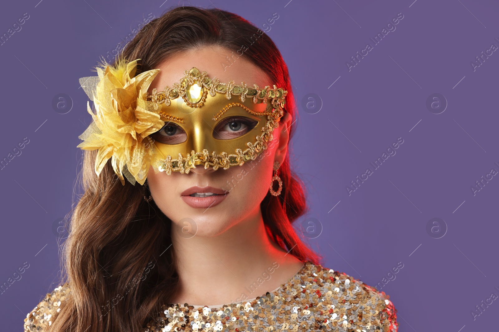 Photo of Beautiful woman wearing carnival mask on purple background, closeup. Space for text