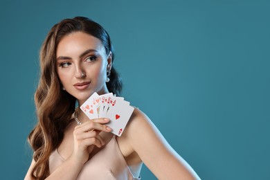 Photo of Poker game. Charming woman with playing cards on light blue background. Space for text