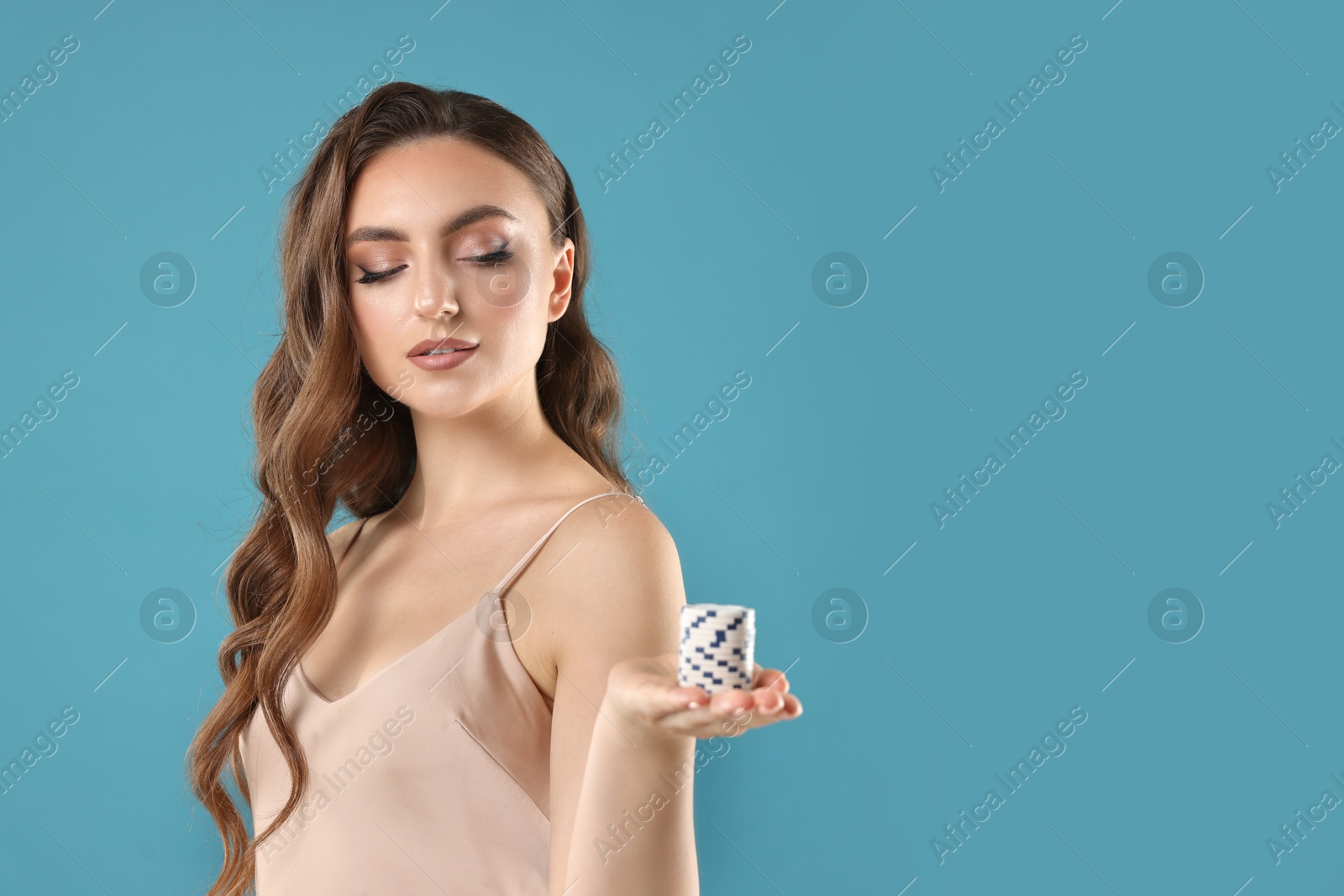 Photo of Charming woman with poker chips on light blue background. Space for text