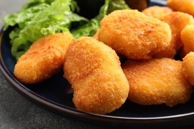 Photo of Tasty chicken nuggets on grey table, closeup