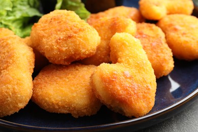 Photo of Tasty chicken nuggets on grey table, closeup