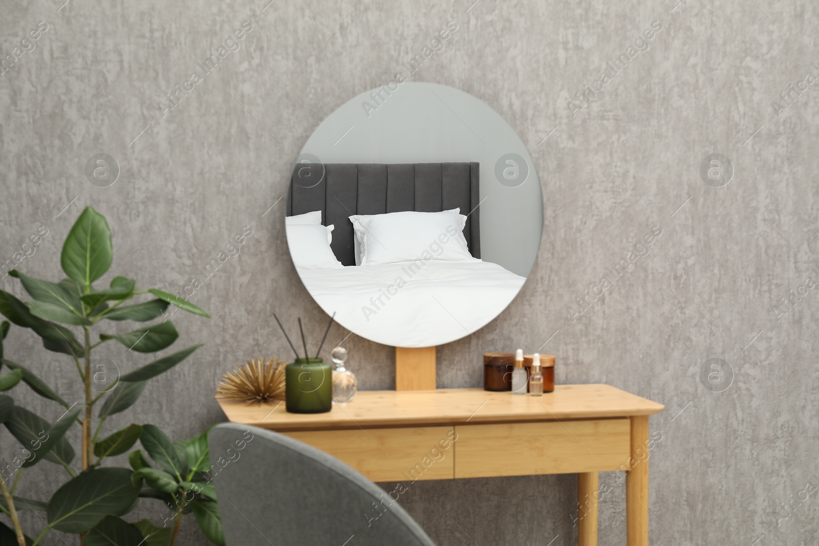 Photo of Round mirror on grey wall in room. Interior design