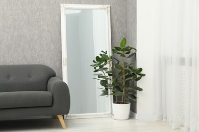 Photo of Large mirror near grey wall in room. Interior design