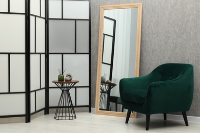 Photo of Large mirror near grey wall in room. Interior design