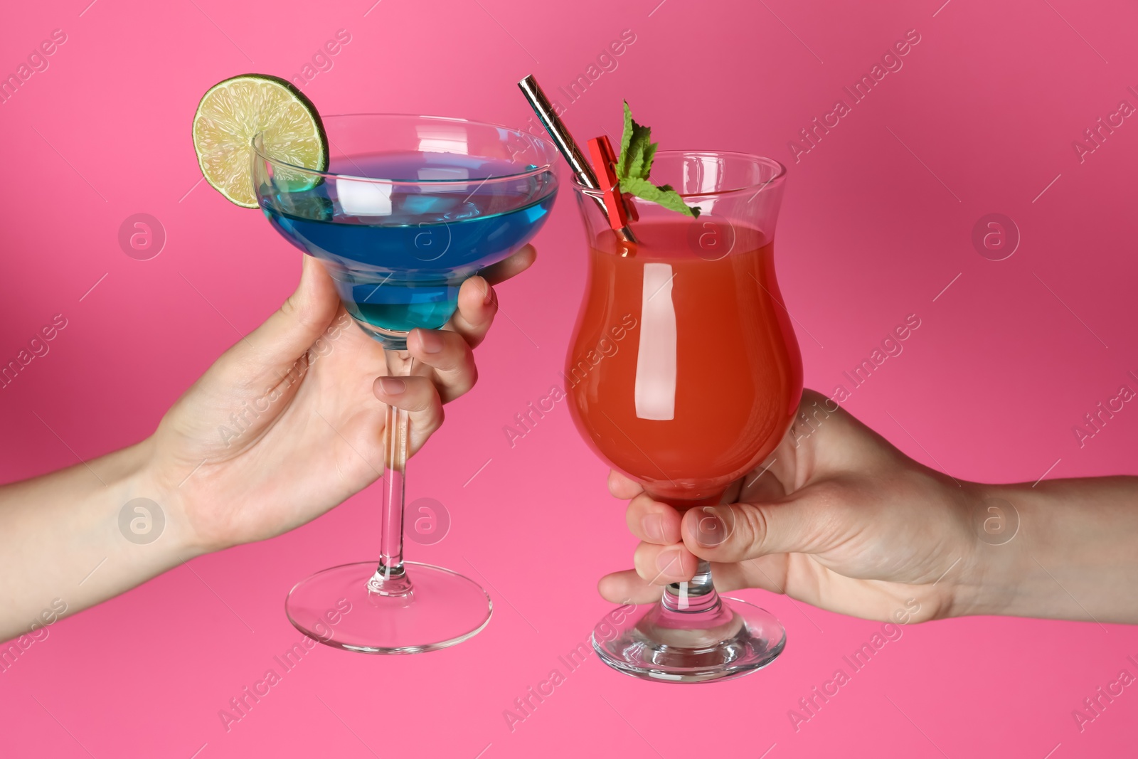 Photo of Friends with glasses of refreshing cocktails on pink background, closeup