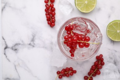 Photo of Refreshing water with red currants in glass on white marble table, flat lay. Space for text