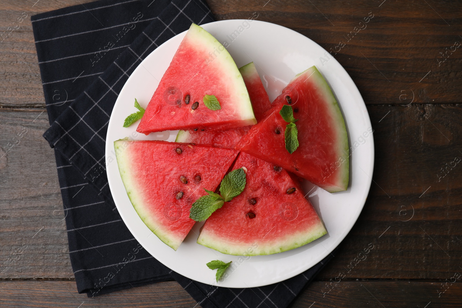 Photo of Fresh watermelon slices with mint leaves on wooden table, top view