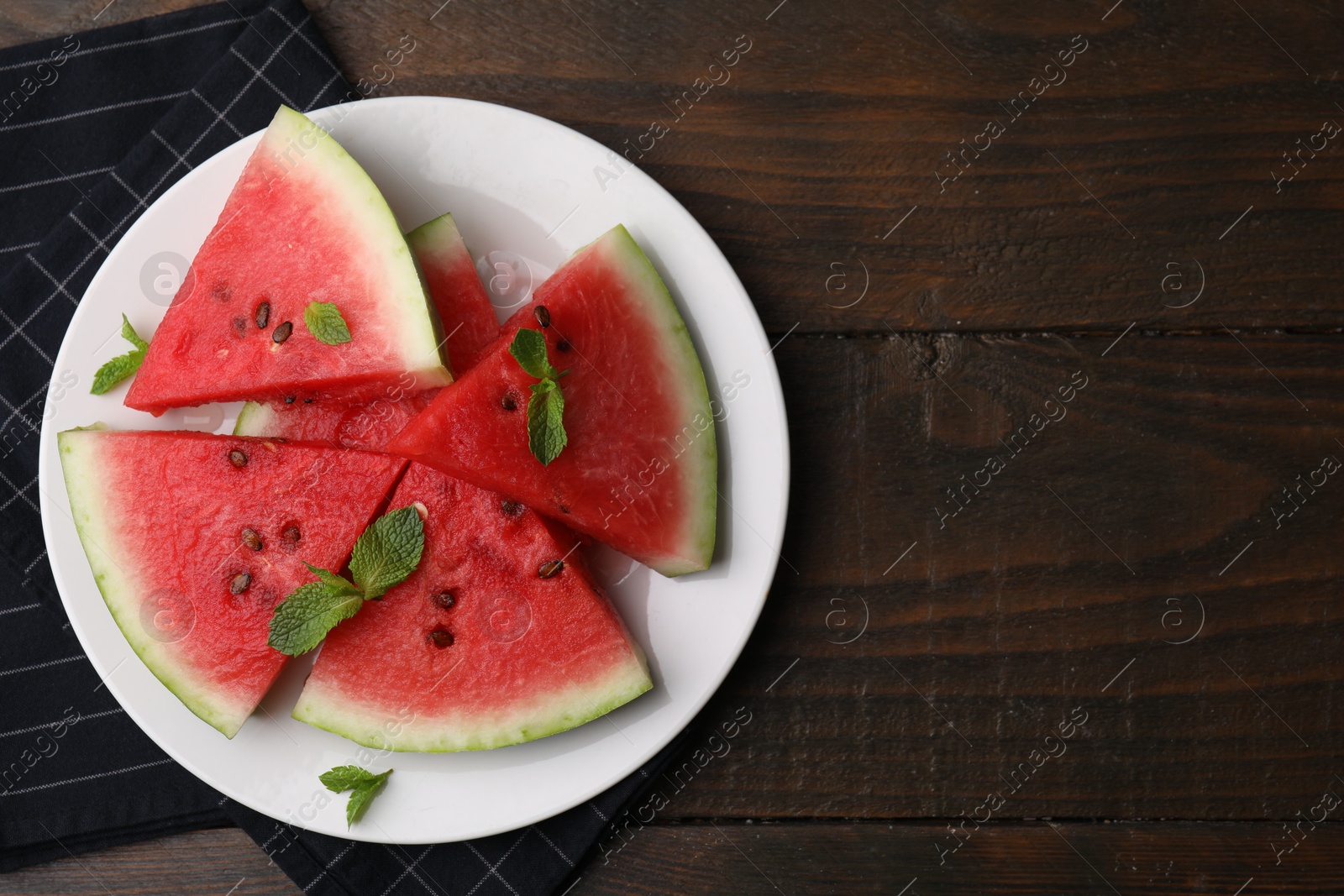 Photo of Fresh watermelon slices with mint leaves on wooden table, top view. Space for text