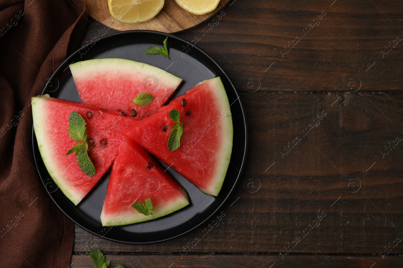 Photo of Fresh watermelon slices with mint leaves on wooden table, flat lay. Space for text