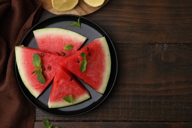 Photo of Fresh watermelon slices with mint leaves on wooden table, flat lay. Space for text