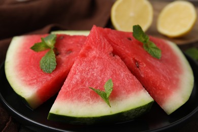 Photo of Fresh watermelon slices with mint leaves on table, closeup