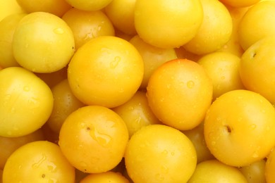 Photo of Many fresh plums with water drops as background, top view