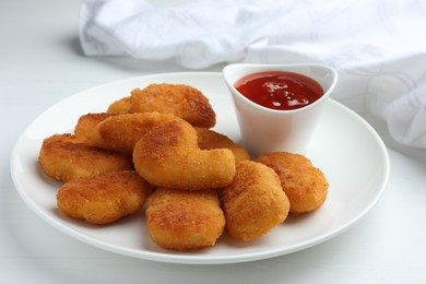 Photo of Tasty chicken nuggets with chili sauce on white table