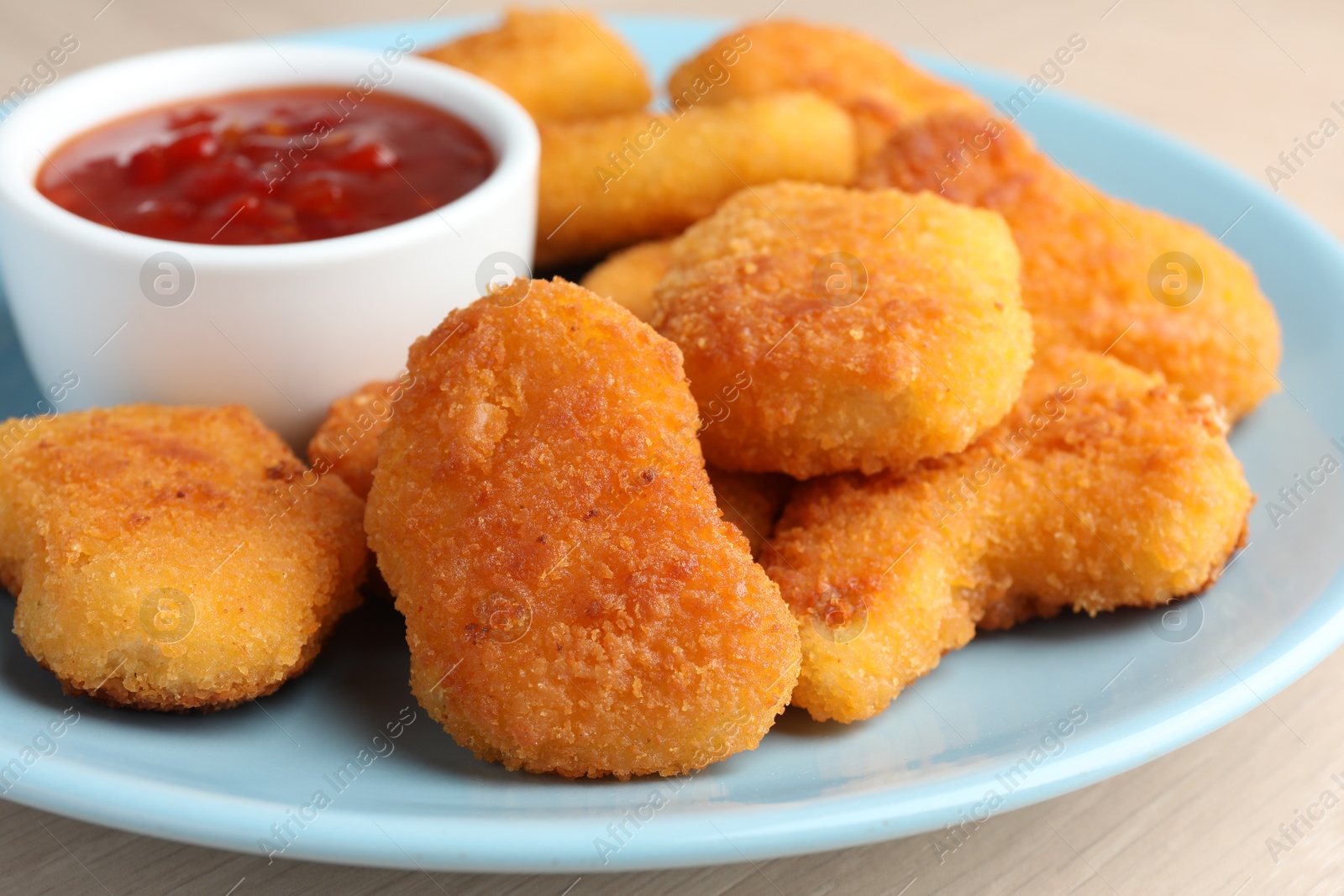 Photo of Tasty chicken nuggets with chili sauce on table, closeup