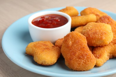 Photo of Tasty chicken nuggets with chili sauce on table, closeup