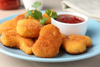 Photo of Tasty chicken nuggets with chili sauce and parsley on table, closeup