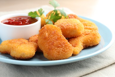 Photo of Tasty chicken nuggets with chili sauce and parsley on table, closeup