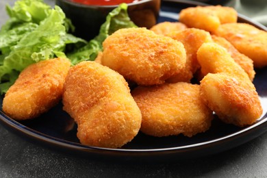 Photo of Tasty chicken nuggets on grey table, closeup