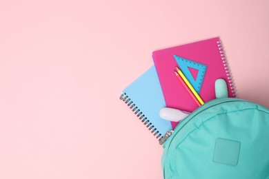 Photo of Backpack with different school stationery on pink background, top view. Space for text