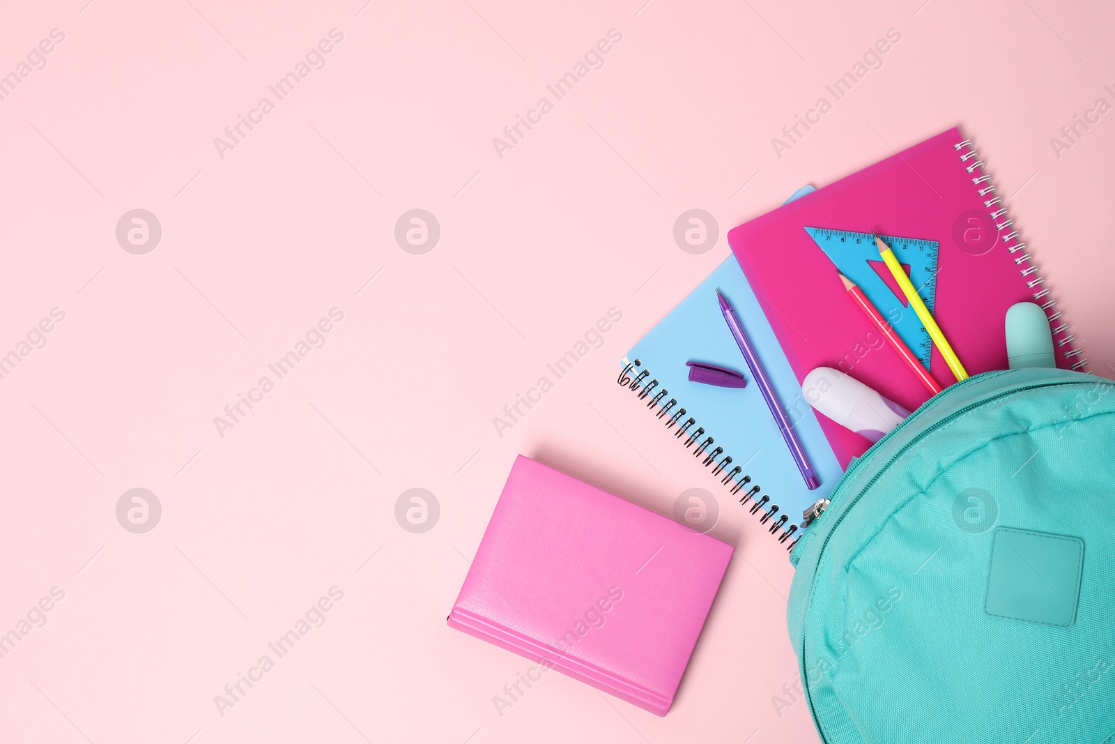 Photo of Backpack with different school stationery on pink background, flat lay. Space for text