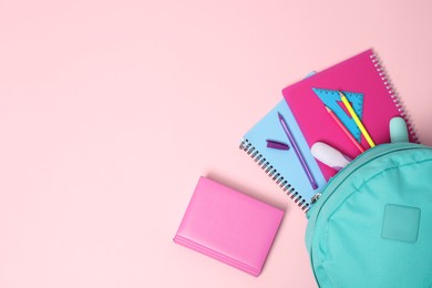 Photo of Backpack with different school stationery on pink background, flat lay. Space for text