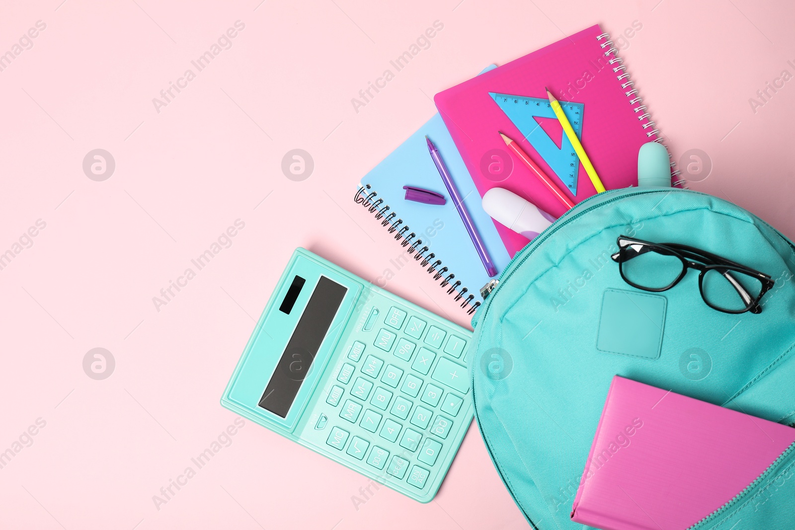 Photo of Backpack with different school stationery on pink background, flat lay. Space for text