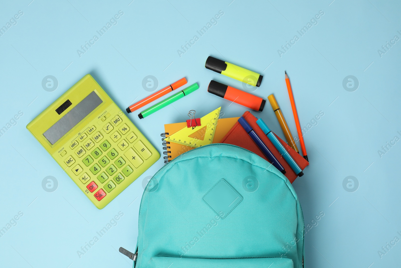 Photo of Backpack with different school stationery on light blue background, flat lay