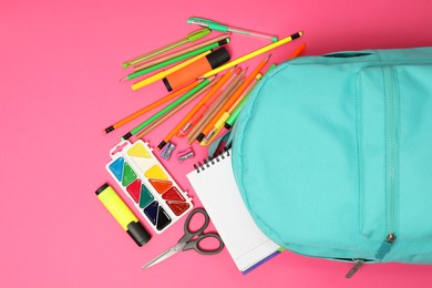 Photo of Backpack and different school supplies on pink background, flat lay