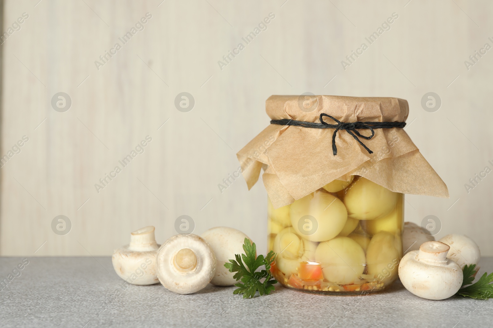 Photo of Tasty pickled mushrooms in jar and fresh ingredients on grey table