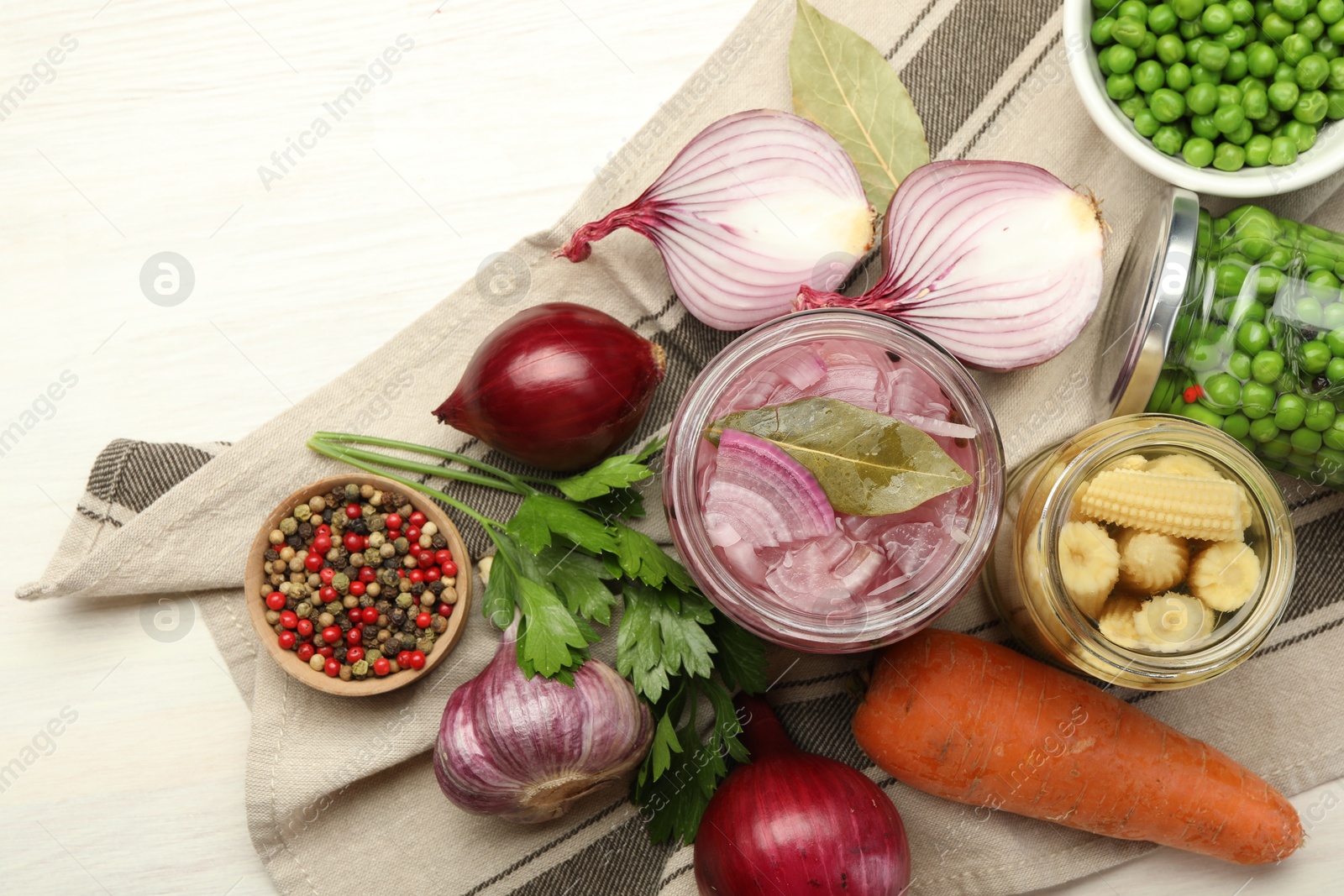 Photo of Different pickled products in jars and fresh ingredients on white wooden table, flat lay