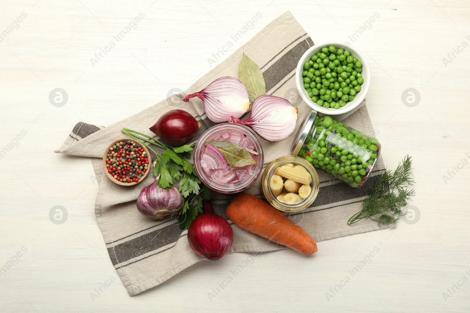 Photo of Different pickled products in jars and fresh ingredients on white wooden table, flat lay