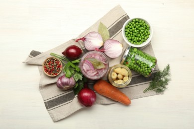 Photo of Different pickled products in jars and fresh ingredients on white wooden table, flat lay