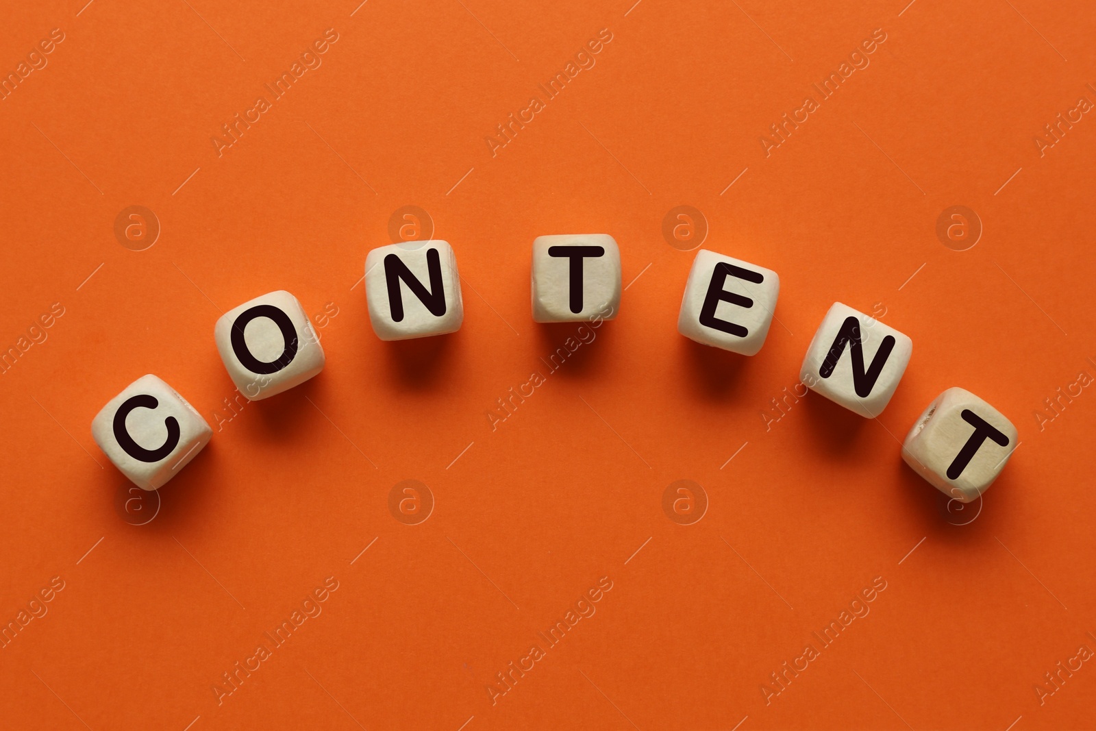 Image of Word Content made of wooden cubes with letters on orange background, top view