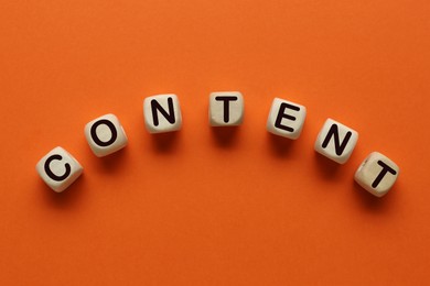 Image of Word Content made of wooden cubes with letters on orange background, top view