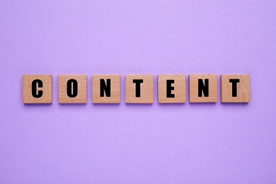 Image of Word Content made of wooden cubes with letters on violet background, top view