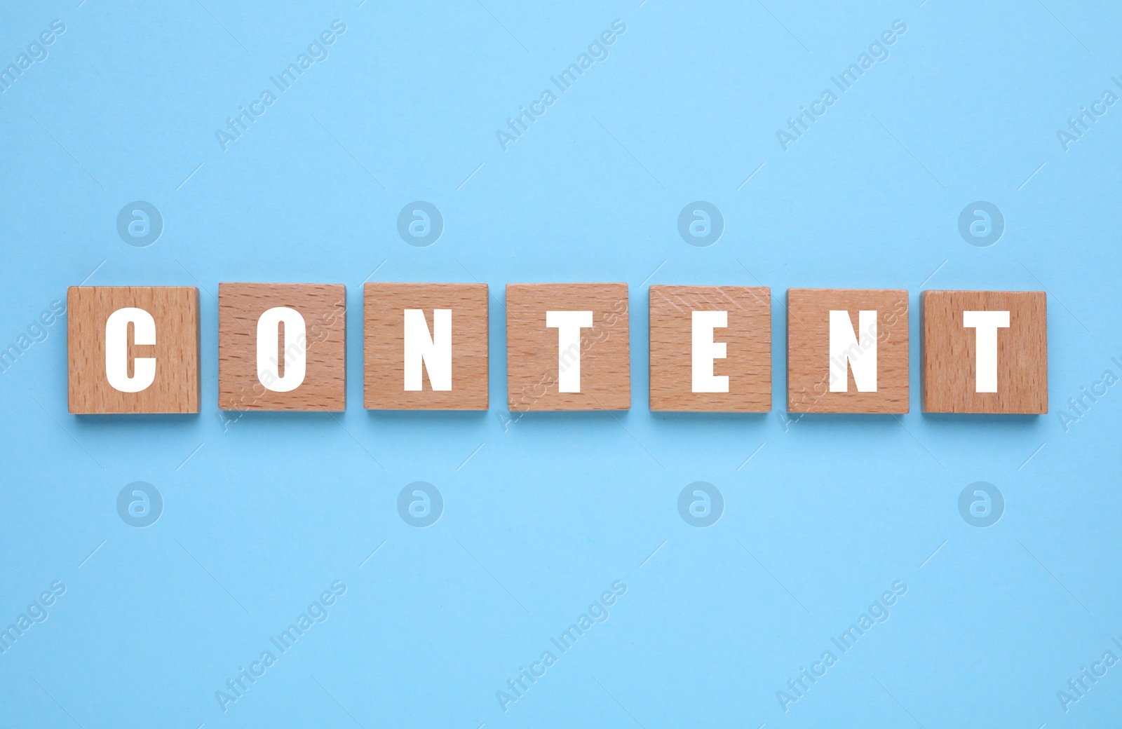 Image of Word Content made of wooden cubes with letters on light blue background, top view