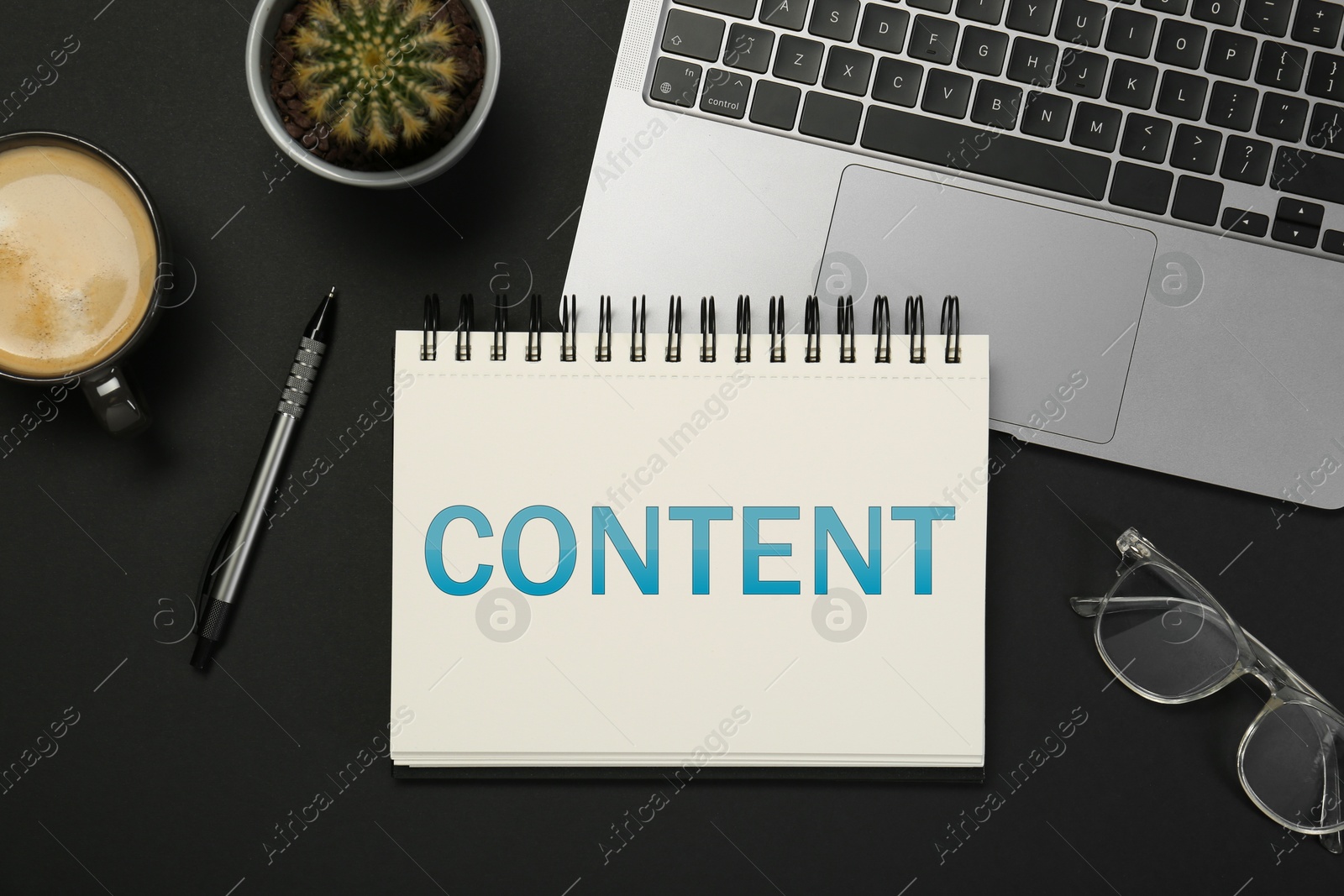 Image of Word Content written in notebook on table. Workplace, top view