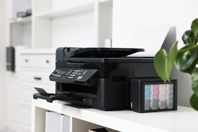 Photo of Modern printer with paper on table in office